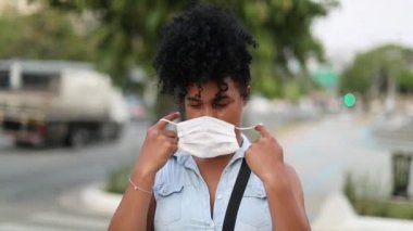 African woman removing covid-19 mask, end of pandemic. Black girl removes disease mask