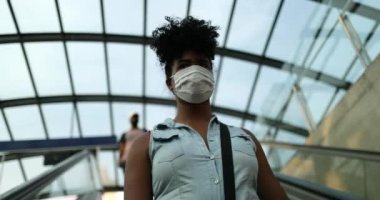 Kadın işe giderken salgın maskesi takıyor asansörden iniyor.