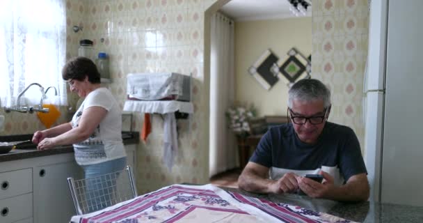 Married Older Couple Kitchen Husband Looking Cellphone Wife Kitchen Sink — Stock videók