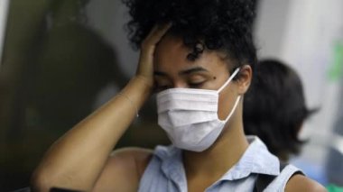 African American woman in metro subway commuting wearing surgical mask