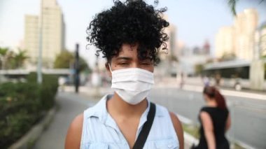 African descent girl wearing covid-19 mask outside in city
