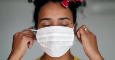 Mutlu genç siyahi kadın salgın maskesini çıkarıyor.