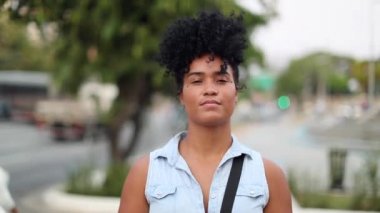 Mixed race black woman portrait looking at camera in city. African american young woman