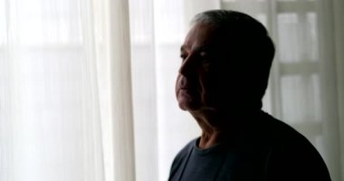Dramatic serious older man standing alone in room