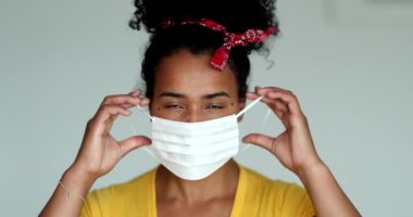 African american woman putting covid-19 face mask prevention against disease