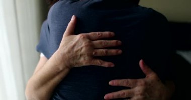 Hands hugging body close-up. Older couple embrace