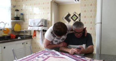 Yaşlı kadın üzgün kocasını cep telefonuyla teselli ediyor.