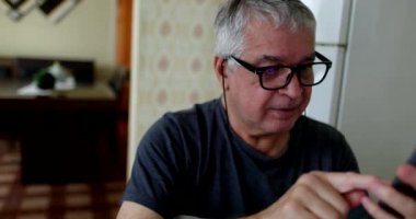 Older man receing great news on cellphone feed. senior celebrating