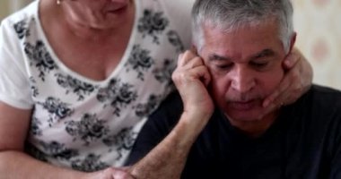 Older wife supporting senior husband through difficulties