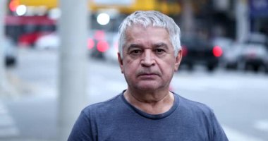 60 yaşındaki bir adam şehirde kameraya gülümsüyor, sıradan ve gerçek insanlar.