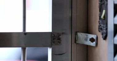 Evden ayrılan kişi demir kapı girişini kapatıyor.