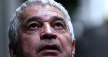 Hopeful senior man looking up to sky with faith