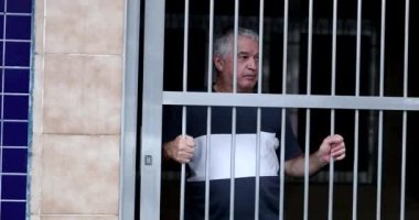 Older man stepping outside sliding garage door. Senior leaving house