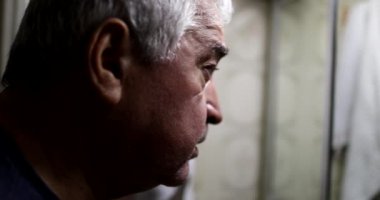 Yaşlı bunalımlı ihtiyar, banyo aynasının önünde.
