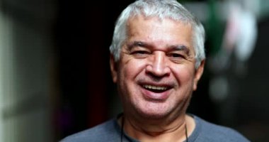 Older senior man smiling and laughing at camera, real life casual person