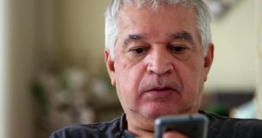 Older man using cellphone. Senior 60 year old browsing internet on smartphone