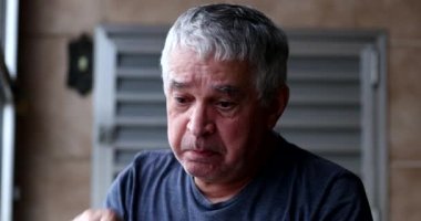 Kızgın, üzgün, orta yaşlı adam ağlıyor, gözyaşlarını siliyor.