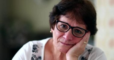 Contemplative older woman looking at camera. Sad thoughtful elder lady portrait