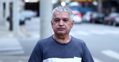 Sıradan bir ihtiyar dışarıda kameraya bakıyor. Kıdemli orta yaşlı kişi