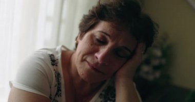 Older woman with eyes closed at home