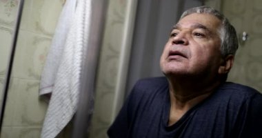 Old man shaking fear from face in front of bathroom mirror