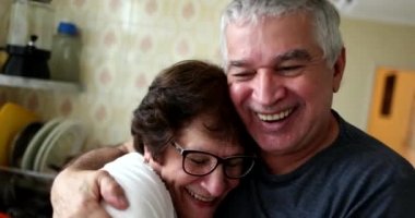 Sevgi ve şefkat gösteren sıradan yaşlı bir çift. Büyük eş evde kocasını öpüyor.