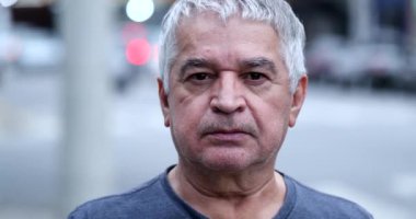 Sıradan bir ihtiyar dışarıda kameraya bakıyor. Kıdemli orta yaşlı kişi