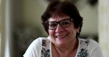 Kameraya gülümseyen yaşlı kadın portresi.