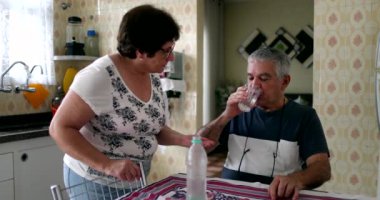 Yaşlı kadın kocaya içmesi için hap veriyor, önleyici ilaç.