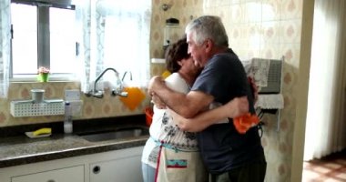 Karı koca başarıyı kutluyor. Yaşlı evli çift sarılıp öpüşüyor.