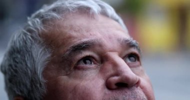 Yakından yaşlı adamın gözleri FAITH ile gökyüzüne bakıyor.