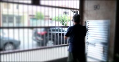 Yaşlı adam garaj kapısından evden ayrılıyor. Son sınıf öğrencisi dışarı çıkıyor.