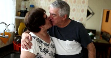 Married older couple kiss and smile portrait. Man kissing wife