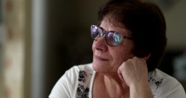 Düşünceli yaşlı kadın hayal kuruyor. Pencereden bakan orta yaşlı kadın.