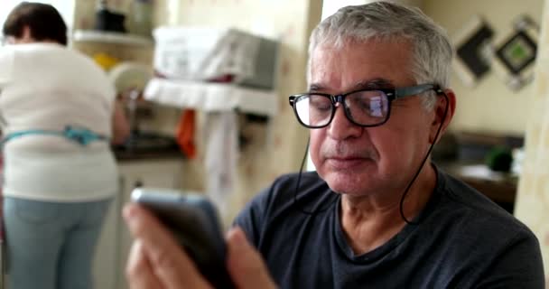 Hombre Mayor Casual Leyendo Contenido Dispositivo Teléfono Inteligente Casa — Vídeos de Stock