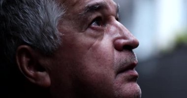 Senior man eyes lifting head to sky with hope and faith