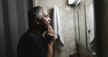 Yaşlı adam çaresizlik içinde tek başına acı çekiyor.