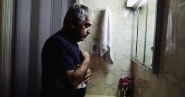 Yaşlı adam elinde haç işareti ile af diliyor.