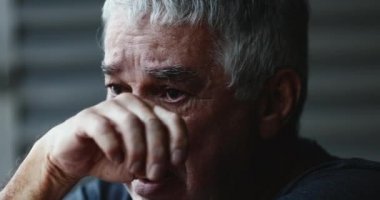Çaresiz yaşlı adam ağlıyor. Yaşlı bunalımda gözyaşlarını siliyor.