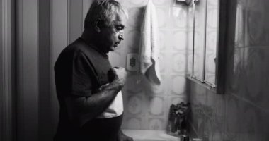 Artistic black and white clip of of old man in the midst of tragedy asking for divine help