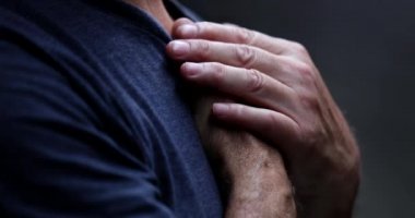 Senior man feeling awe and presence of God, spiritual person with hand in chest praying