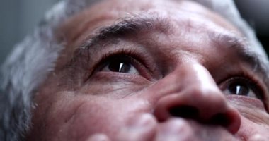 Yaşlı adam gökyüzüne umutla ve inançla bakıyor.