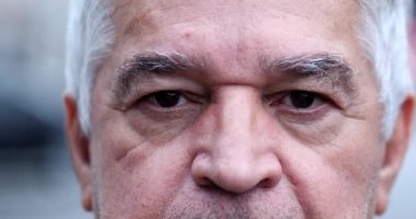 Buruşuk orta yaşlı bir adam. Yakın çekim gözleri. Kameraya bakıyor.