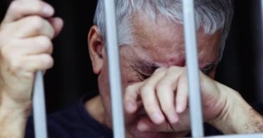 Parmaklıklar ardındaki umutsuz yaşlı adam. Hapisteki kişi
