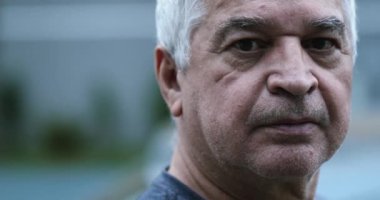 Kameraya bakan yaşlı bir adam, dışarıda orta yaşlı bir portre.