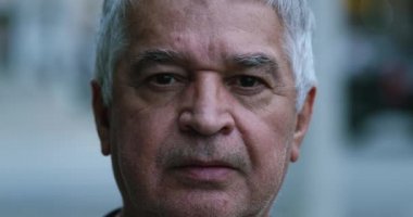 Dışarıda yaşlı bir adam portresi var, orta yaşlı orta yaşlı bir adam kameraya bakıyor.