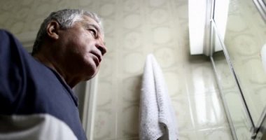 Stresli yaşlı adam banyo aynasının önünde. Orta yaş krizi