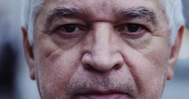 Senior man close-up eyes looking at camera, wrinkled 60 year old person