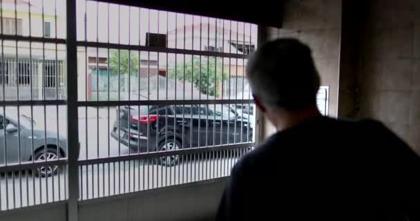 老人はガレージの門を通って家を出る 外に出る — ストック動画