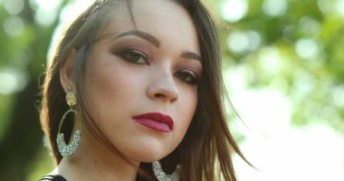 Açık hava parkında poz veren düşünceli genç bir kız. Düşünceli genç bir kadın portresinin dışında.